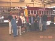 A group of senior citizens standing in front of a fire truck.